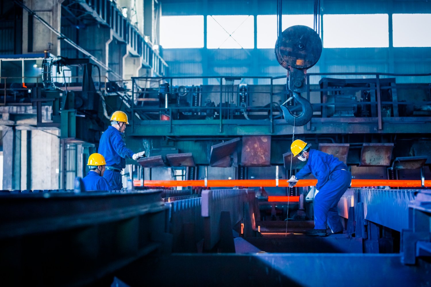 Workers handling hot metal inside a foundry
