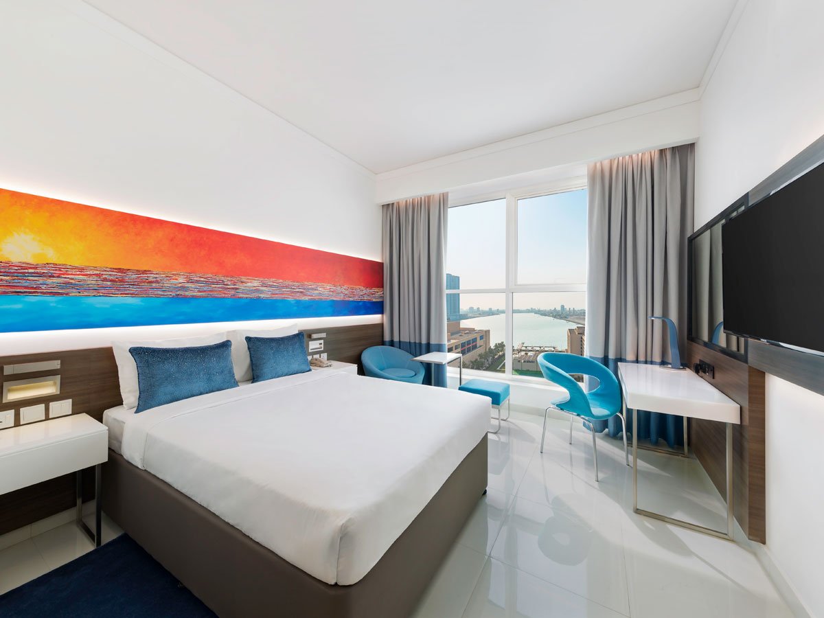 Bright hotel room with blue accents and a waterfront view