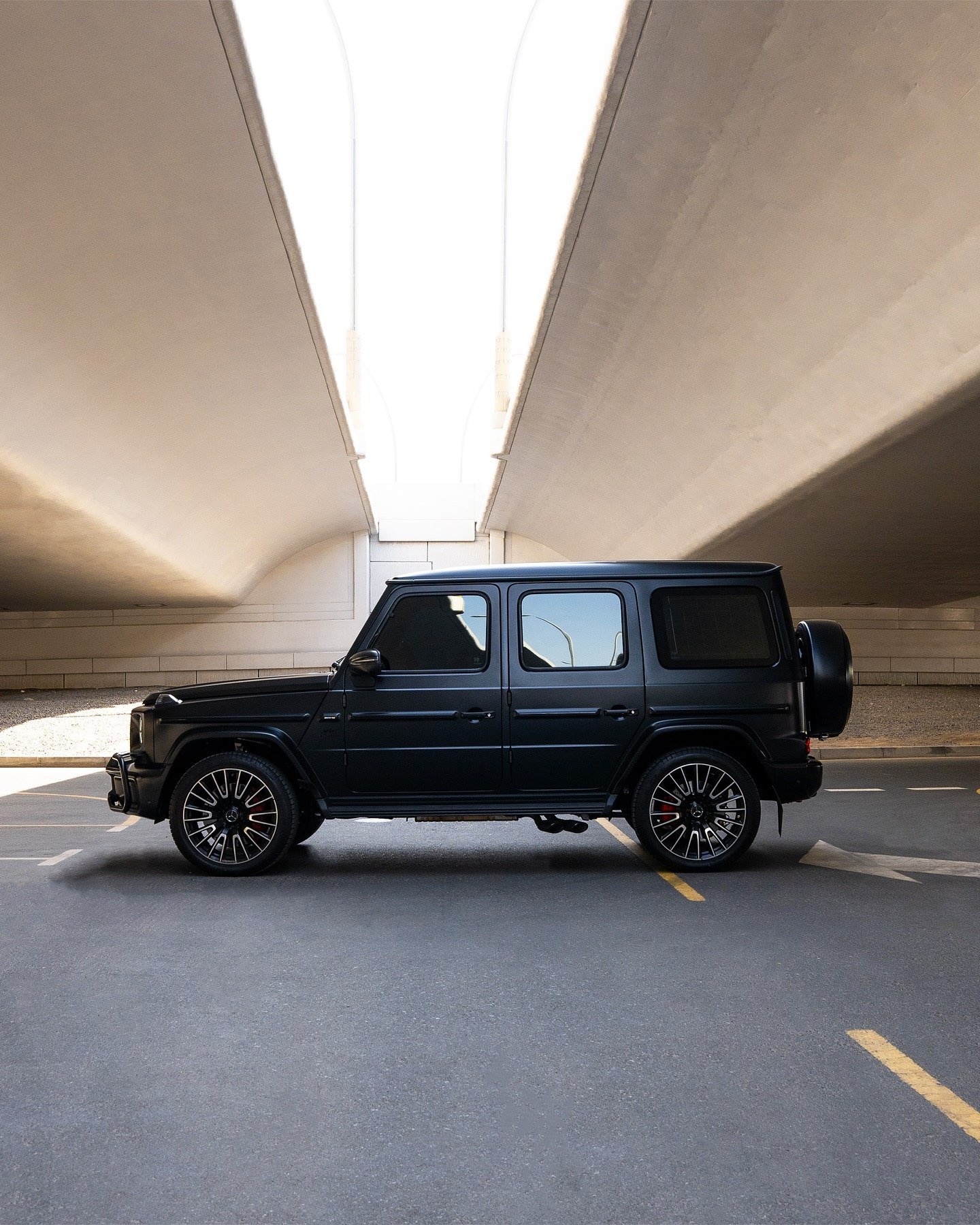 Black SUV photographed beneath a concrete underpass